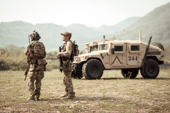 soldiers standing around a military vehicle